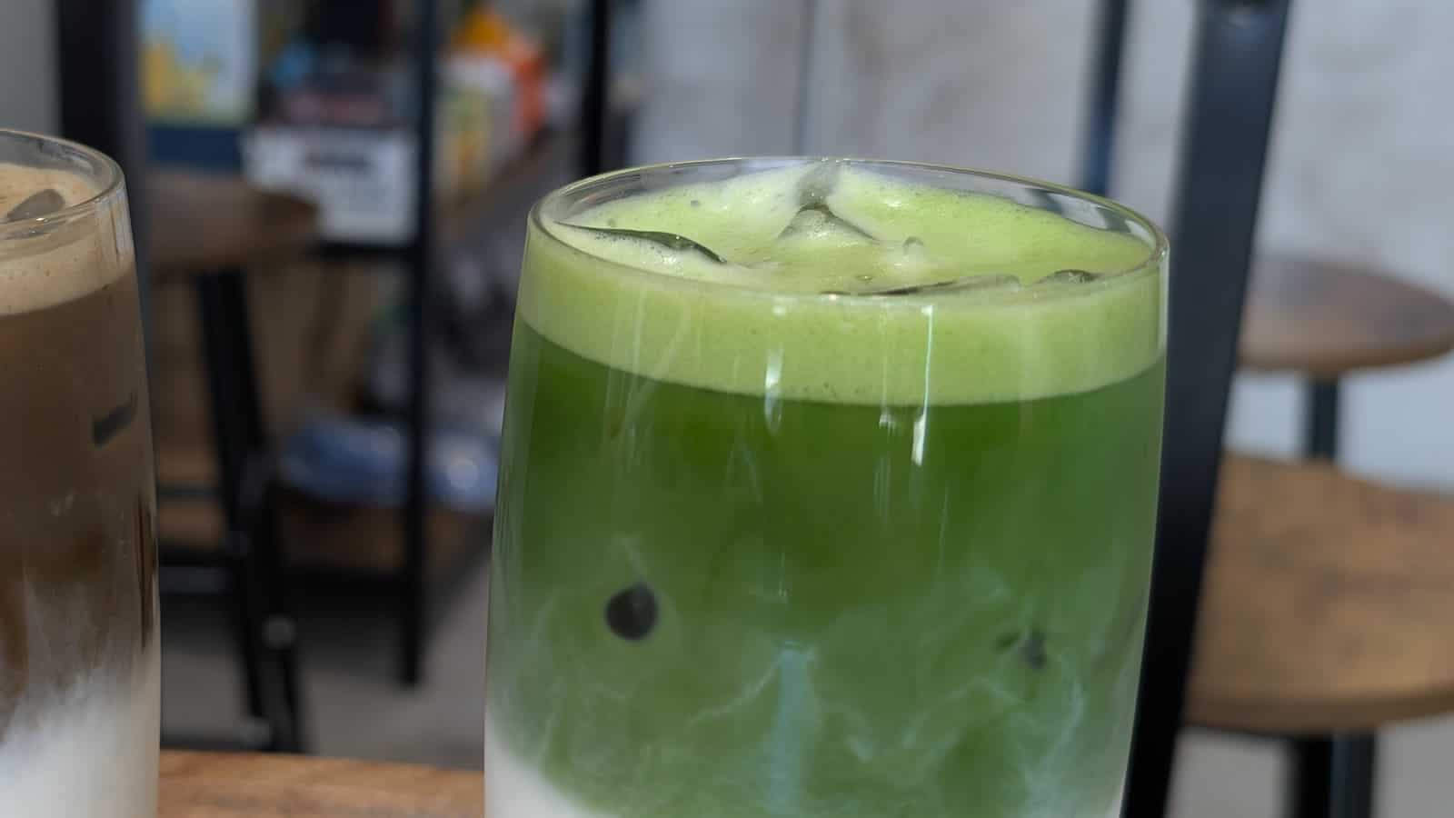 uzun bardakta katmanlı buzlu matcha latte: altta süt, üstte matcha