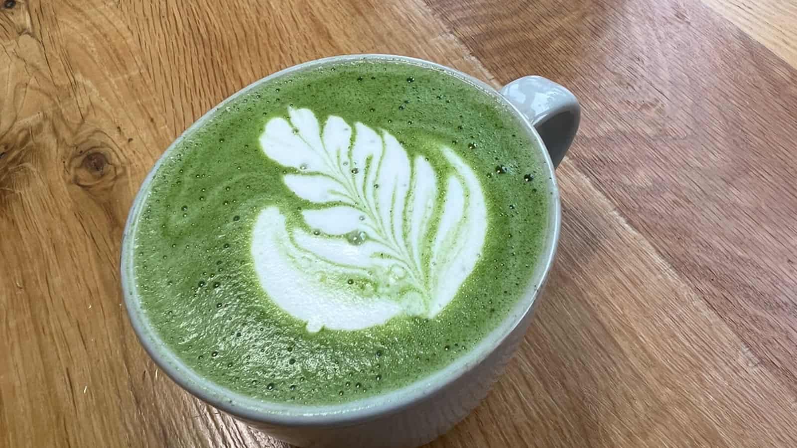 Yeşil çay latte, sanatlı latte sanatı ile sunulmuş.